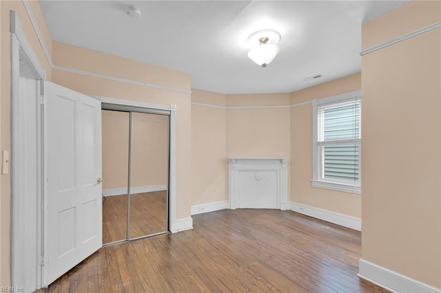 unfurnished bedroom featuring wood-type flooring and a closet