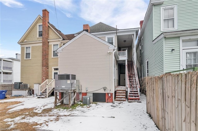 snow covered rear of property with central air condition unit