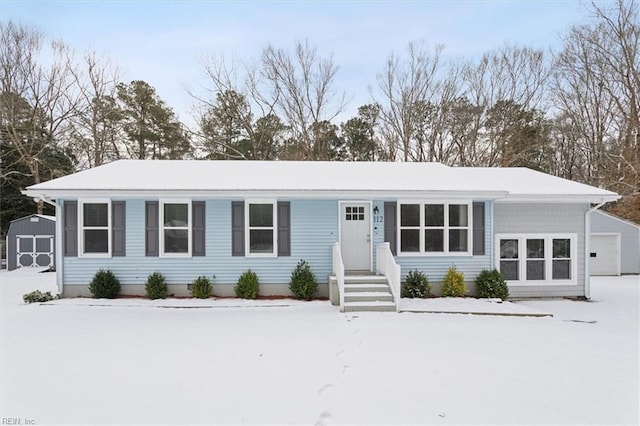 single story home with a storage shed and a garage