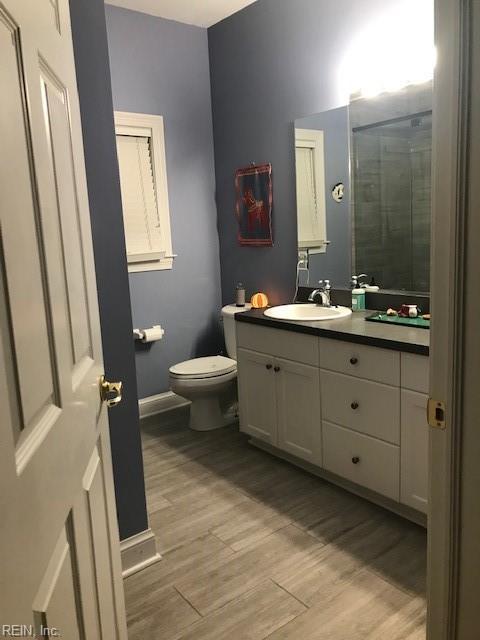 bathroom with vanity, hardwood / wood-style floors, an enclosed shower, and toilet