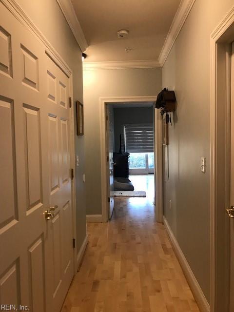 hallway featuring crown molding and light hardwood / wood-style floors