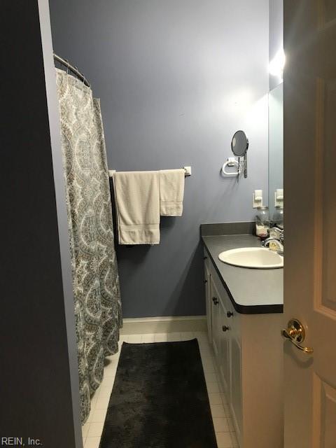 bathroom with vanity, curtained shower, and tile patterned floors