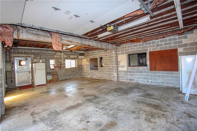 garage featuring white refrigerator and a garage door opener