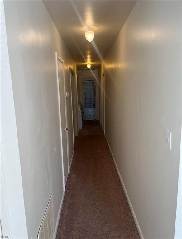 hallway featuring dark colored carpet