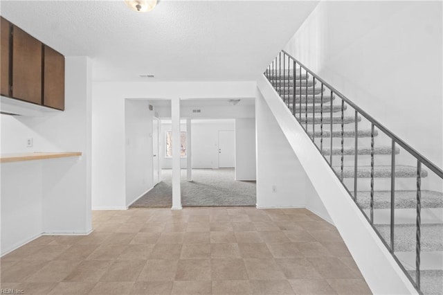 staircase with a textured ceiling