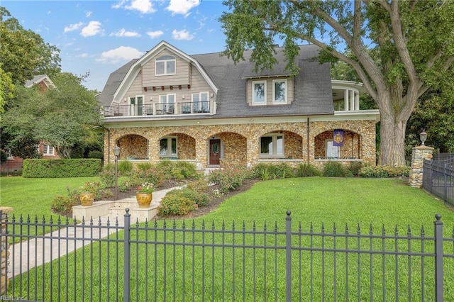 view of front of house featuring a front yard, a balcony, and covered porch