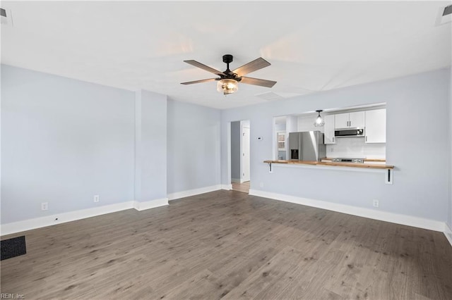 unfurnished living room featuring hardwood / wood-style floors and ceiling fan