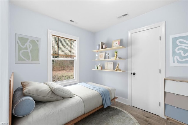 bedroom with multiple windows and light hardwood / wood-style flooring