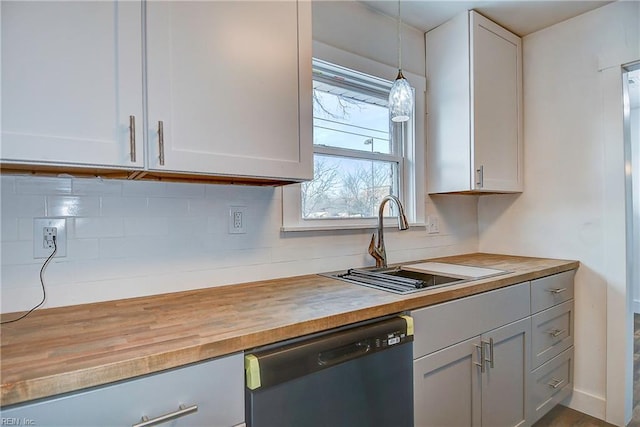 kitchen featuring sink, wooden counters, black dishwasher, pendant lighting, and decorative backsplash