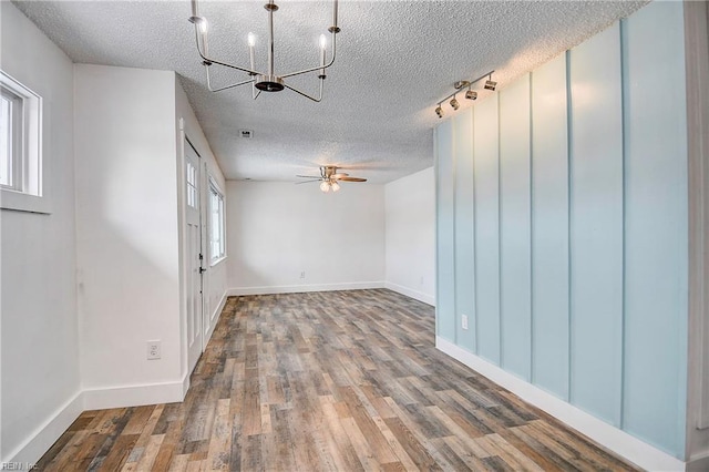 unfurnished room with hardwood / wood-style flooring, ceiling fan with notable chandelier, and a textured ceiling