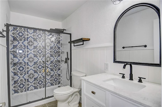 bathroom with tile patterned floors, vanity, toilet, and an enclosed shower