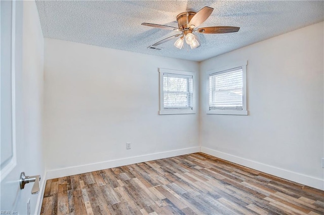 spare room with a textured ceiling, ceiling fan, and light hardwood / wood-style flooring