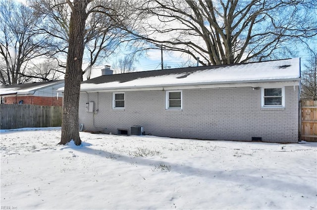 snow covered property with central AC unit