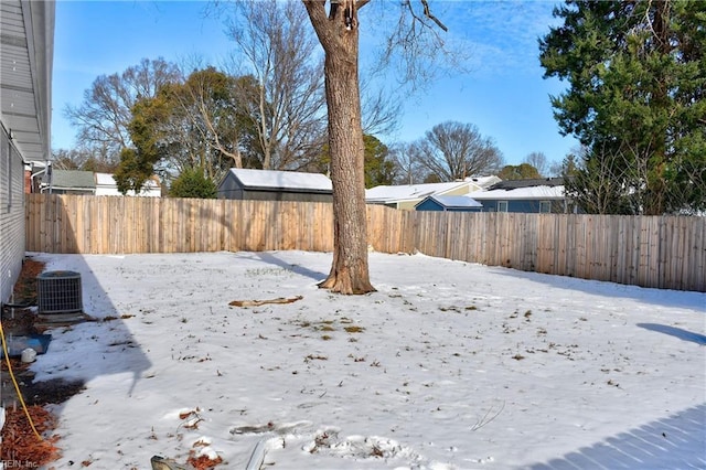 snowy yard featuring cooling unit