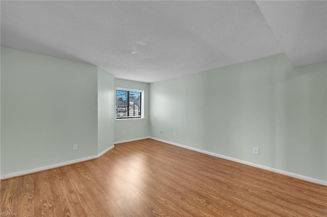 unfurnished room featuring light hardwood / wood-style floors and a textured ceiling