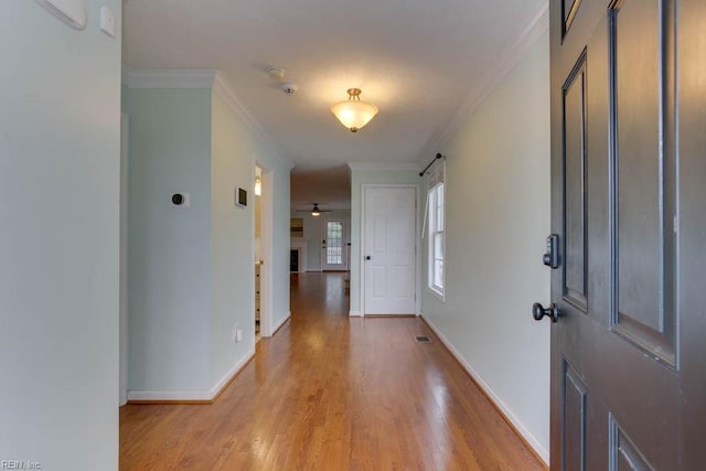 entrance foyer featuring ornamental molding, light hardwood / wood-style floors, ceiling fan, and a barn door