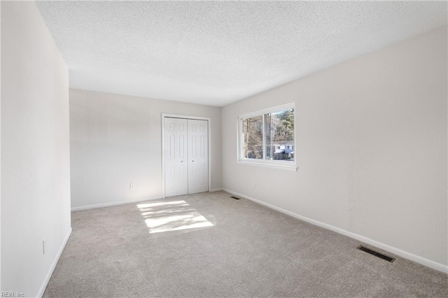 empty room featuring a textured ceiling and carpet flooring