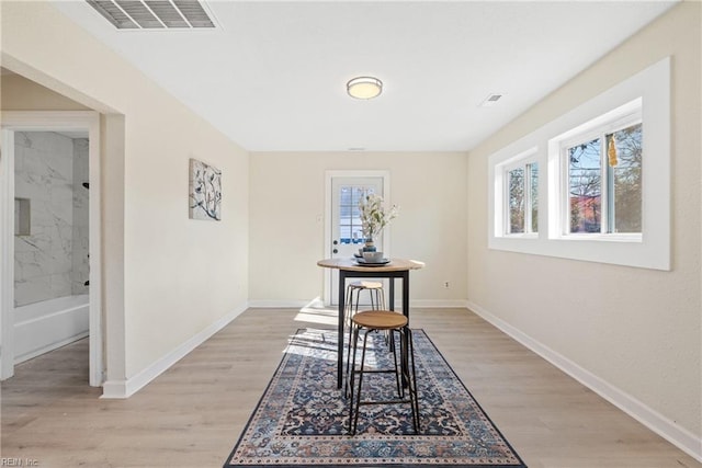 hall featuring a healthy amount of sunlight and light hardwood / wood-style floors