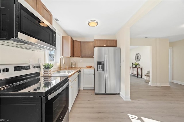 kitchen featuring stainless steel appliances, sink, and light wood-type flooring