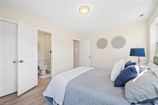 bedroom featuring ensuite bath and light hardwood / wood-style floors