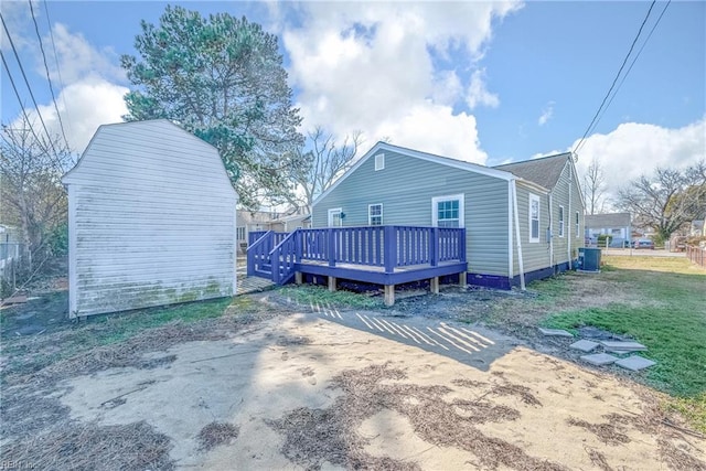 back of house with a wooden deck and central AC