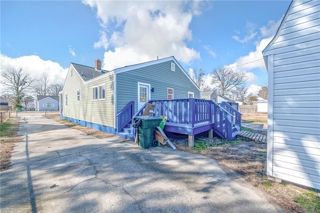 rear view of house featuring a wooden deck