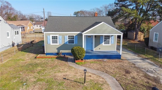 bungalow with a porch, a storage unit, and a front yard