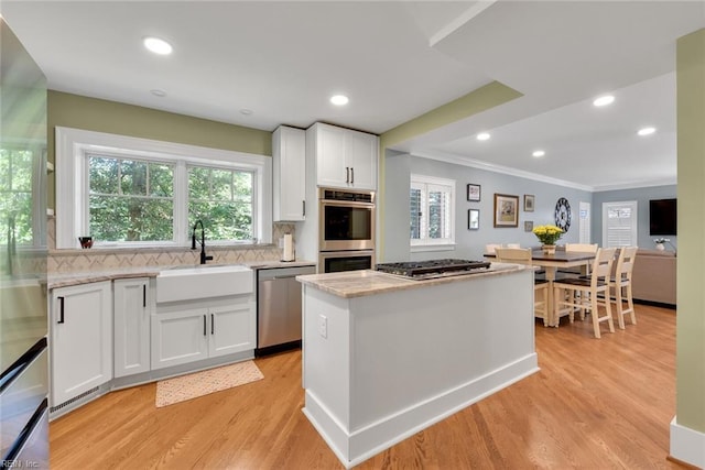 kitchen featuring light stone countertops, appliances with stainless steel finishes, sink, and white cabinets