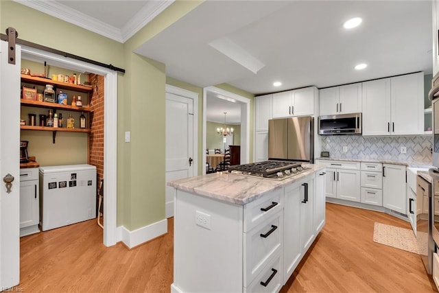 kitchen with white cabinetry, stainless steel appliances, light hardwood / wood-style floors, and a kitchen island