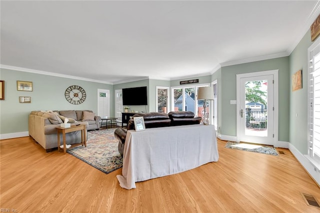 living room featuring crown molding and light hardwood / wood-style flooring