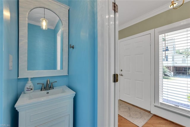 bathroom with vanity, hardwood / wood-style floors, and ornamental molding