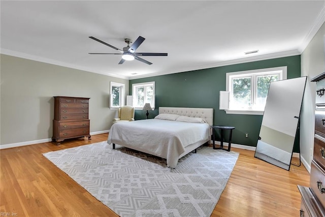 bedroom with ornamental molding, ceiling fan, and light wood-type flooring