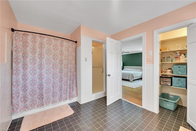 bathroom with tile walls, tile patterned floors, and walk in shower