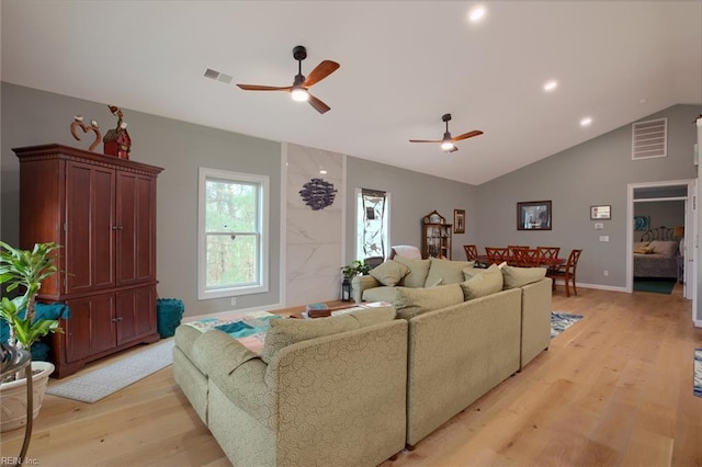 living room with ceiling fan, vaulted ceiling, and light hardwood / wood-style flooring