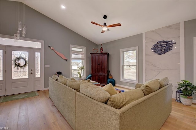 living room with lofted ceiling, light hardwood / wood-style floors, and plenty of natural light