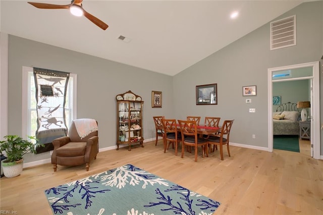 dining room featuring hardwood / wood-style floors, high vaulted ceiling, and ceiling fan