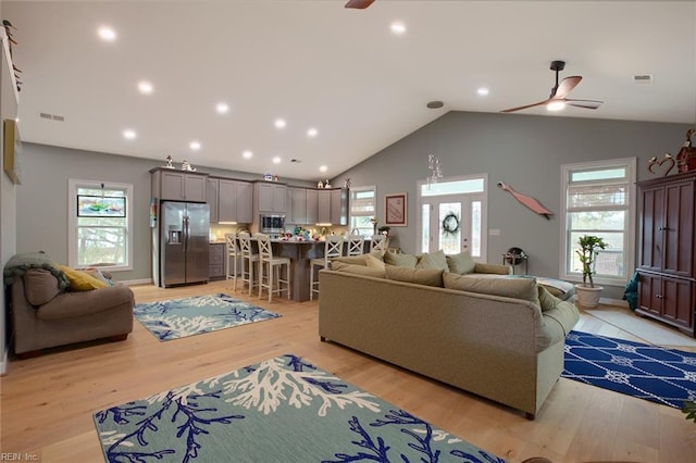 living room with vaulted ceiling, ceiling fan, and light hardwood / wood-style flooring