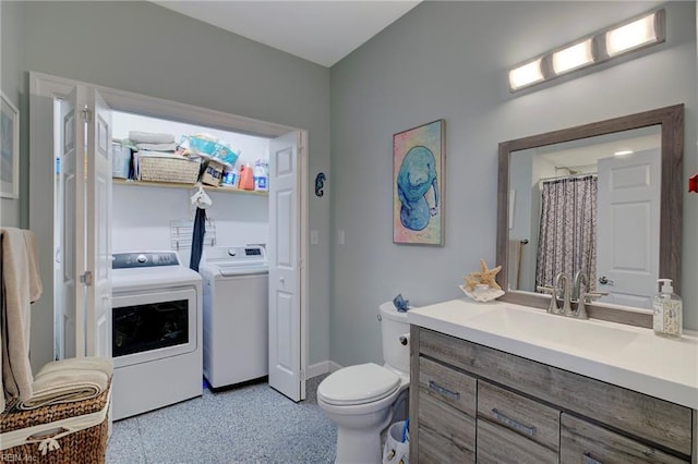 bathroom with vanity, washer and clothes dryer, toilet, and walk in shower