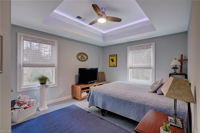 bedroom with ceiling fan, ornamental molding, a tray ceiling, and light colored carpet