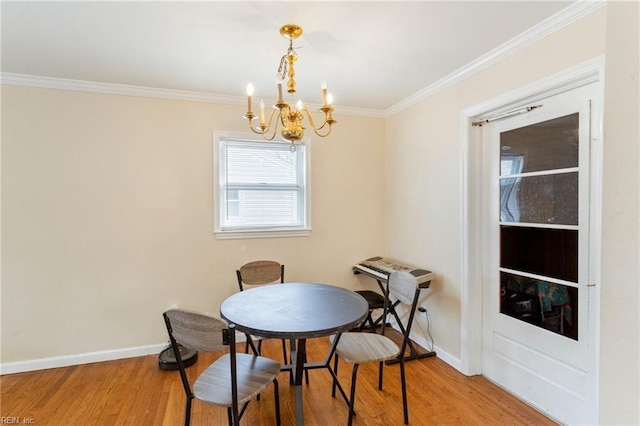 dining space featuring ornamental molding, hardwood / wood-style floors, and an inviting chandelier