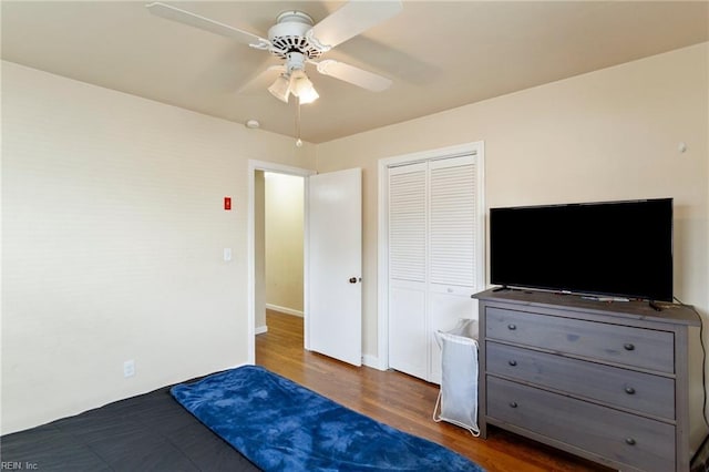 bedroom featuring dark hardwood / wood-style flooring, a closet, and ceiling fan