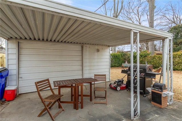 view of patio / terrace with grilling area, a garage, and an outdoor structure