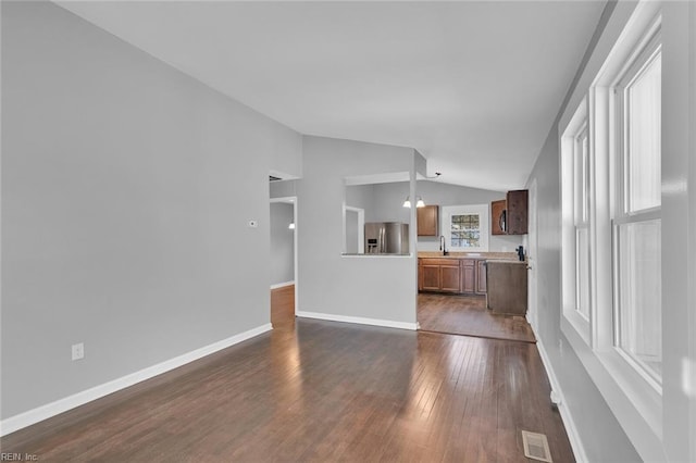 unfurnished living room with lofted ceiling, dark hardwood / wood-style flooring, and sink