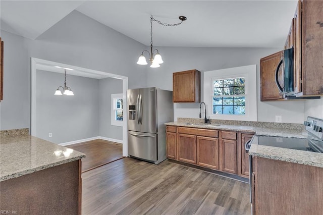 kitchen featuring a notable chandelier, decorative light fixtures, stainless steel fridge, and sink