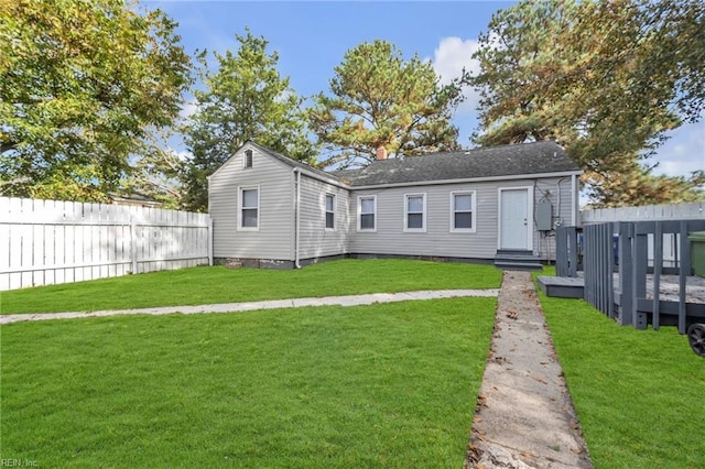 back of property featuring a wooden deck and a lawn