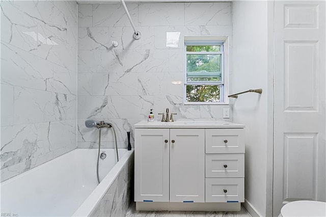 bathroom featuring tiled shower / bath, tile walls, and vanity