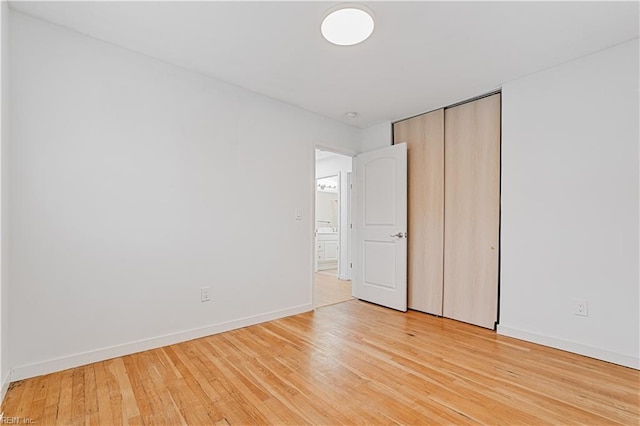 unfurnished bedroom featuring a closet and light wood-type flooring