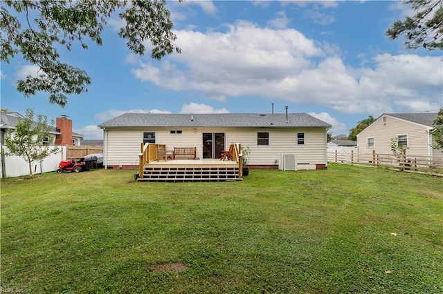 back of property with central AC, a deck, and a lawn