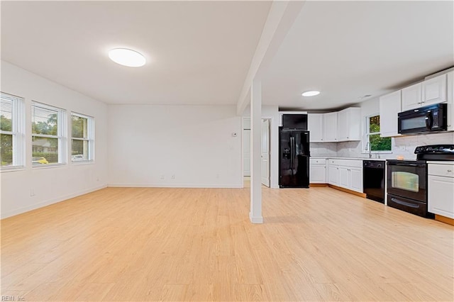 kitchen with backsplash, black appliances, white cabinets, and light wood-type flooring