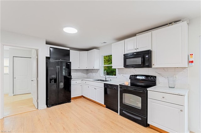 kitchen featuring white cabinetry, sink, tasteful backsplash, and black appliances